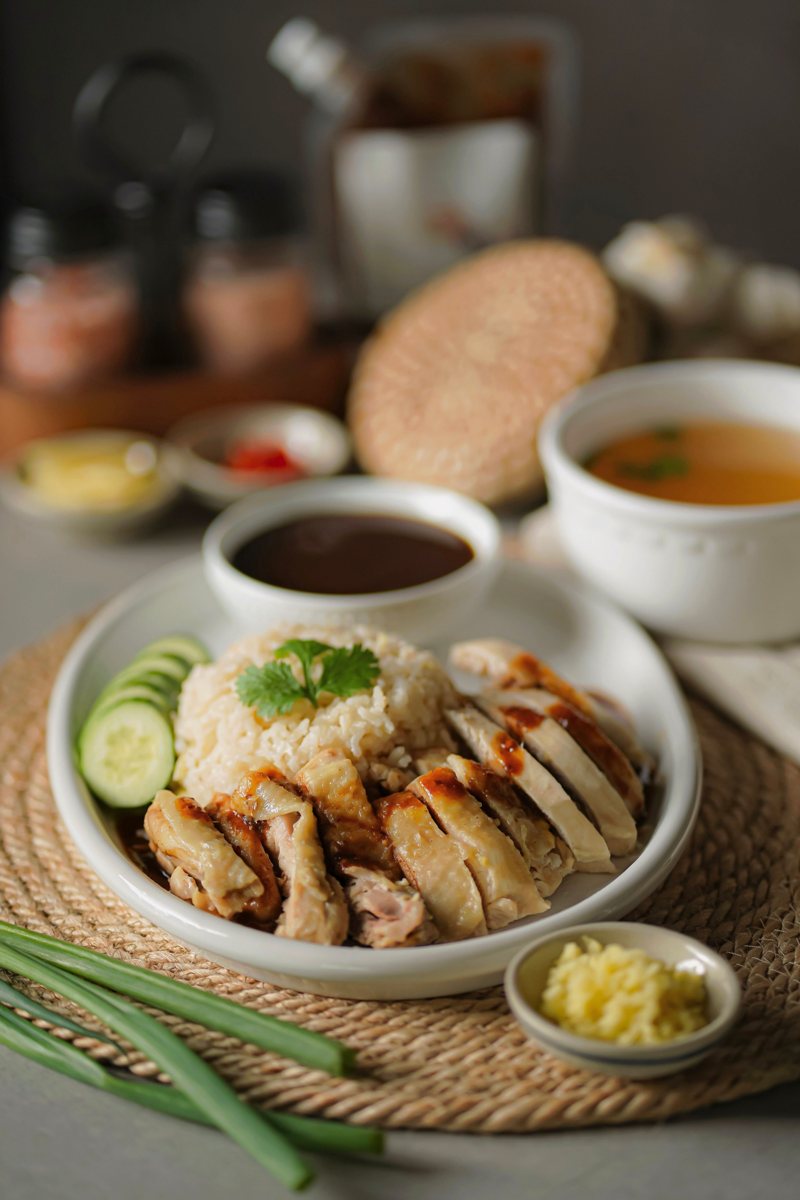 Hainanese chicken rice served with soup and dipping sauces