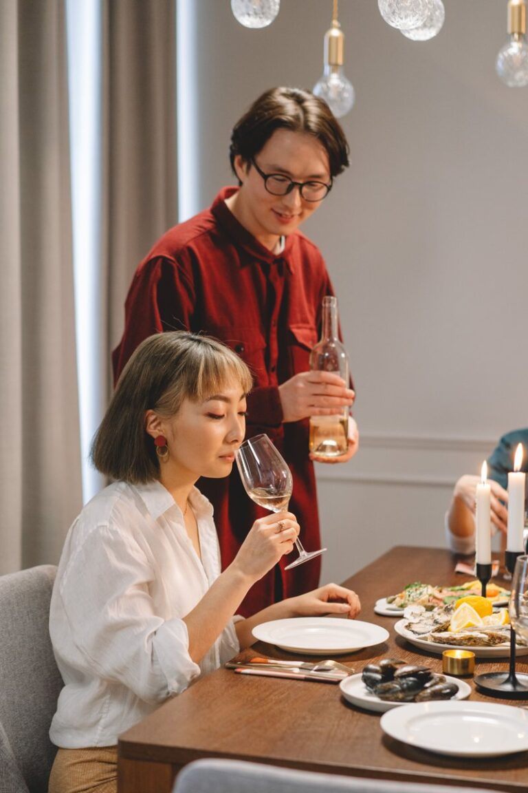 Adults enjoying white wine over a candlelit dinner